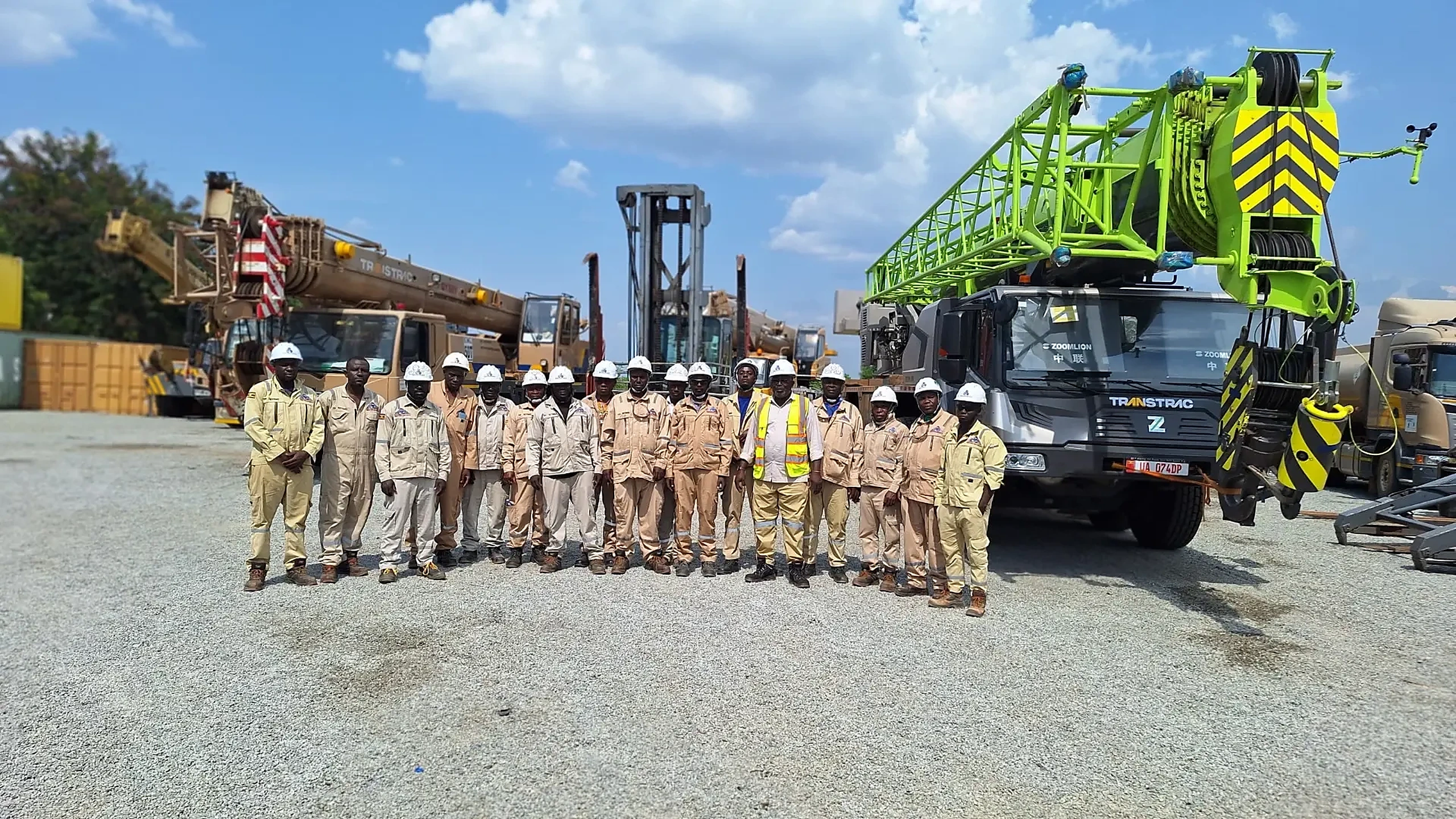 Heavy equipment operators gathered in front of mobile cranes after safety training